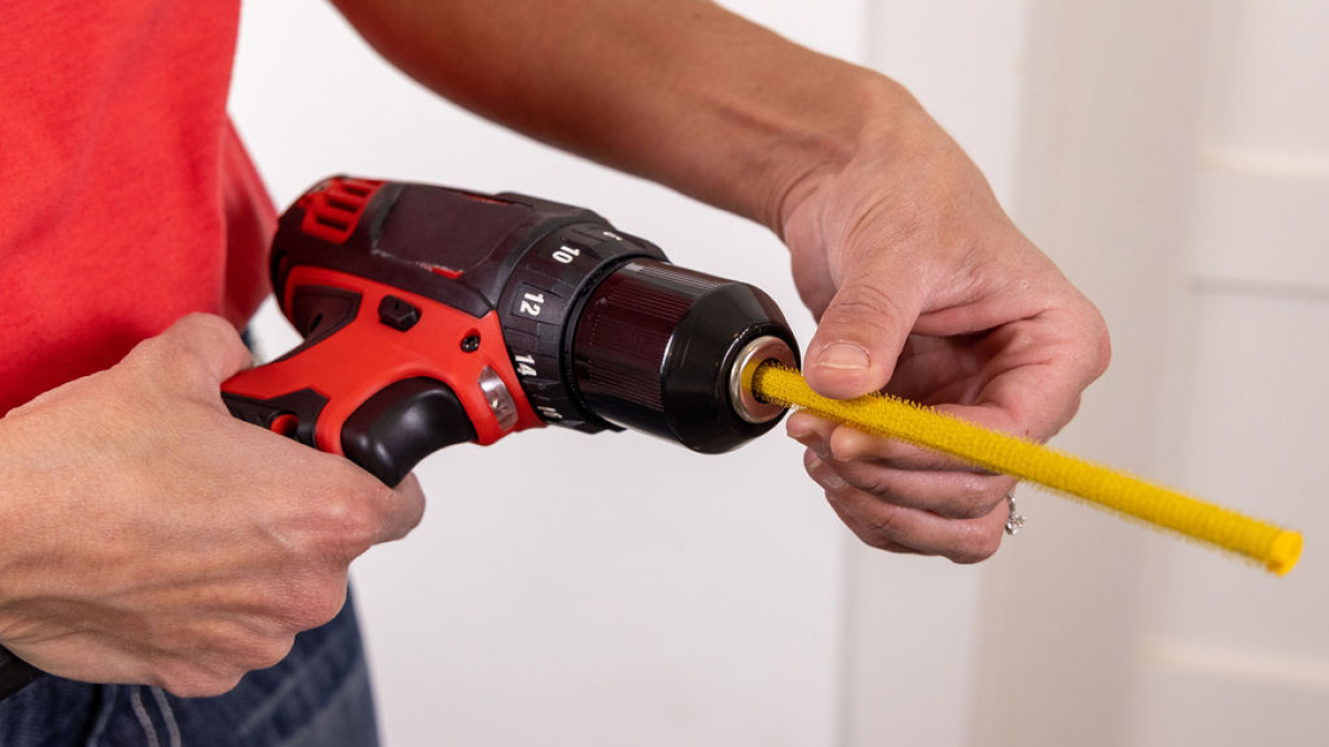 Man attaching Vacuum Weasel to handheld drill